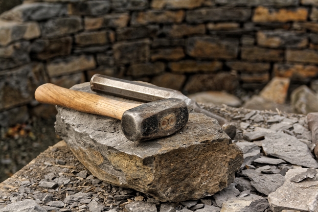 2 lb sledge hammer and chisel placed upon a flat stone